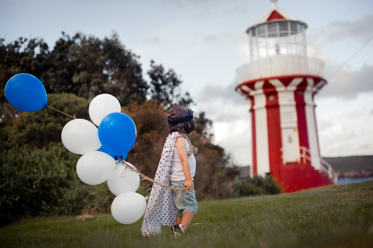 Boy at lighthouse, styled shoot with red and white theme.