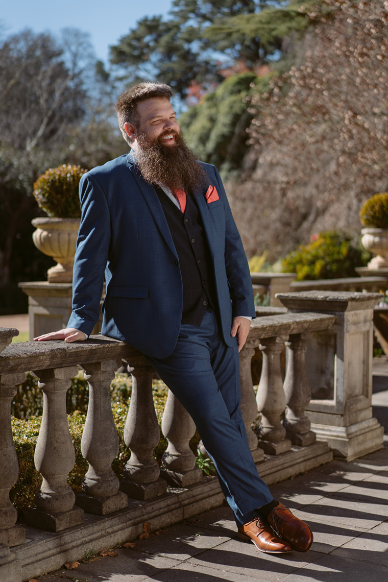 Full length groom portrait infront of Milton Park Pool House.