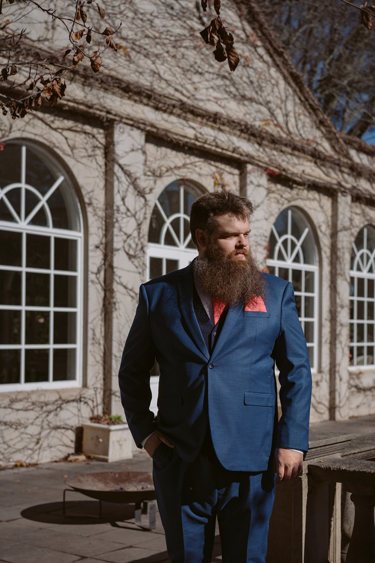 Full length groom portrait infront of Milton Park Pool House.