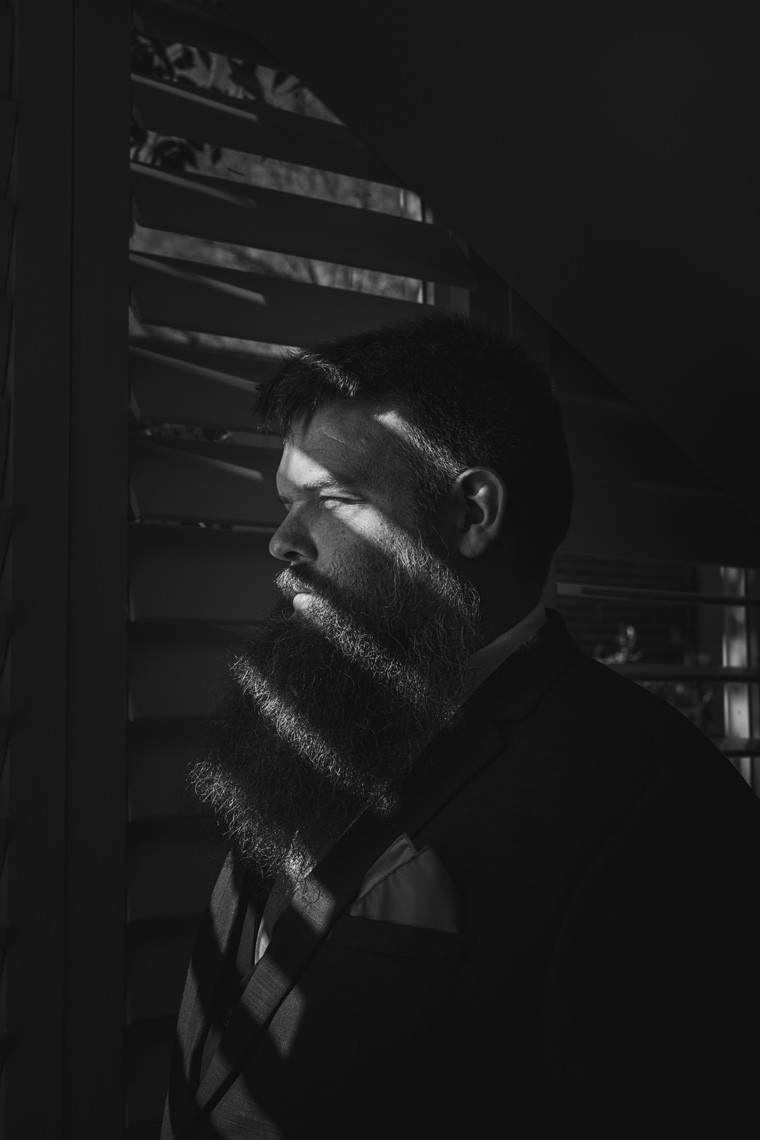 Stunning low key black and white groom portrait.