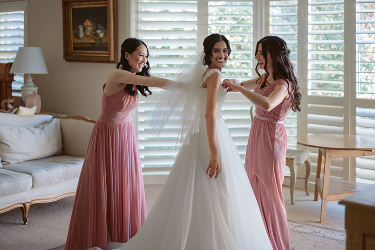 Bride getting dressed by her bridesmaids in the Bridal Suite at Milton Park Country House