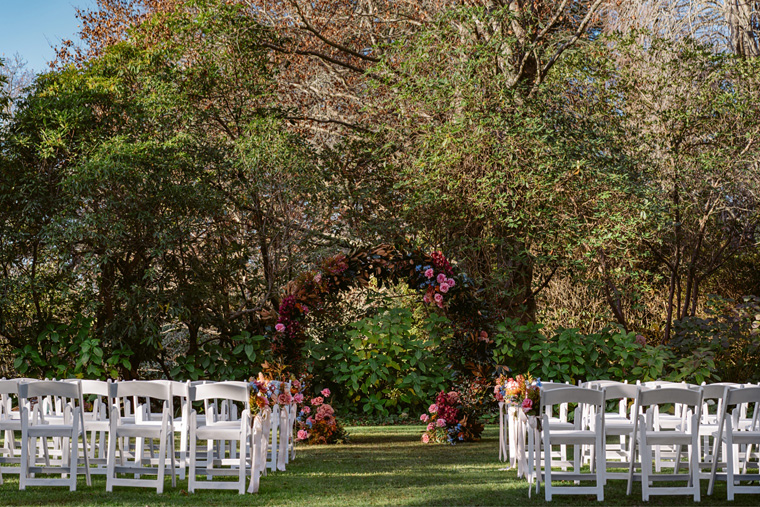 Outdoor wedding ceremony setup with a beautiful floral archway.