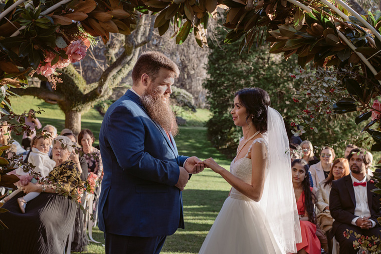 Groom exchanges rings with bride.