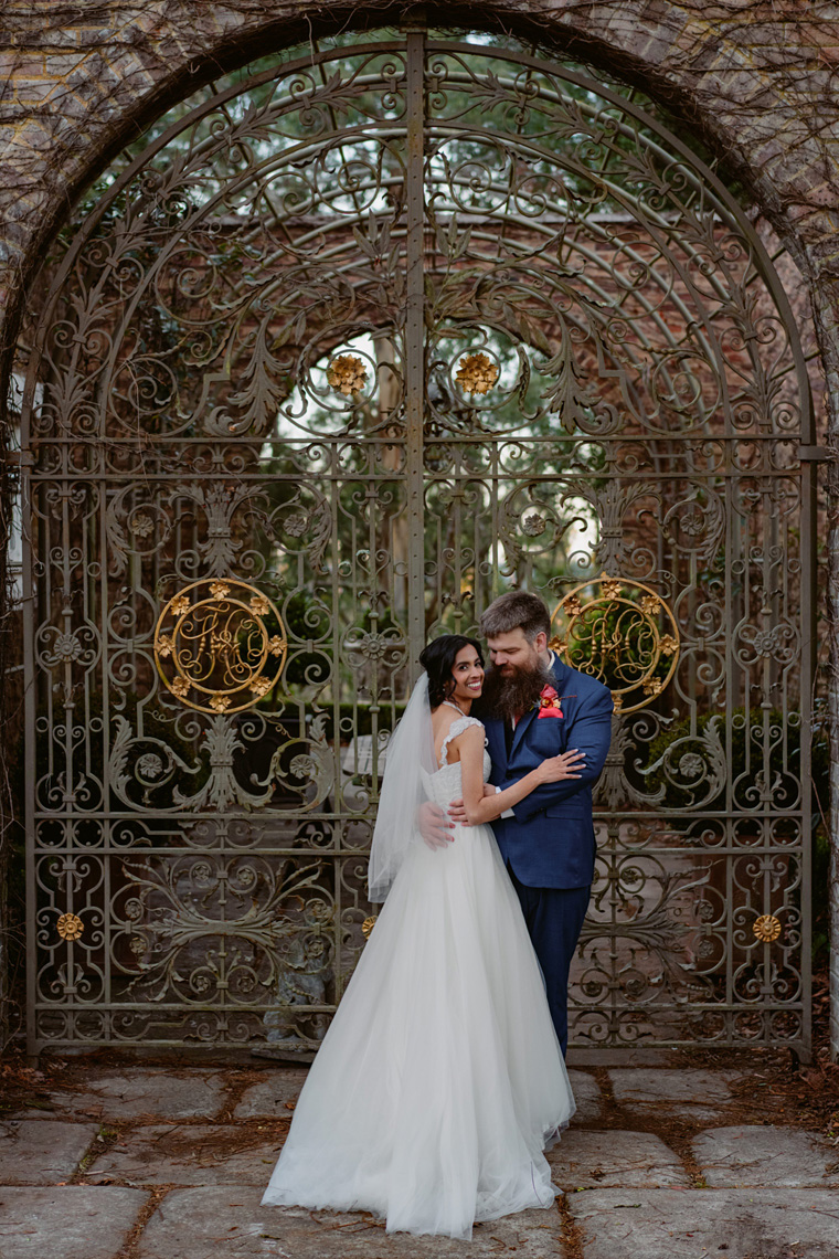 Newlywedded couple pose infront of The Coach House gates near Bowral.