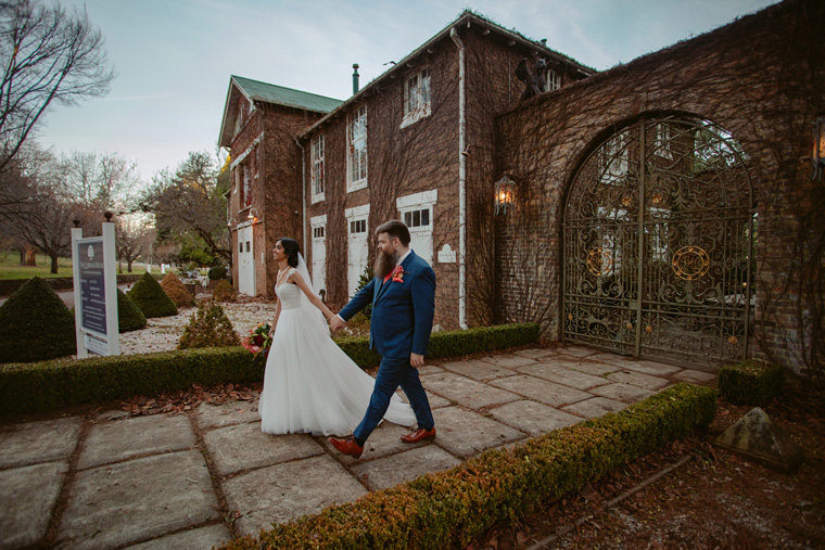 Couple walk down path away from The Coach House, Bowral.