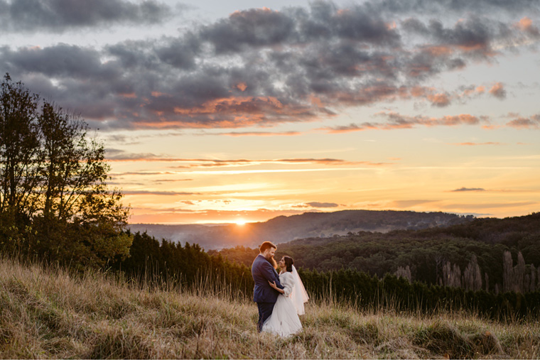 Wedding couple embrace in a country field at The Southern Highlands, Bowral.