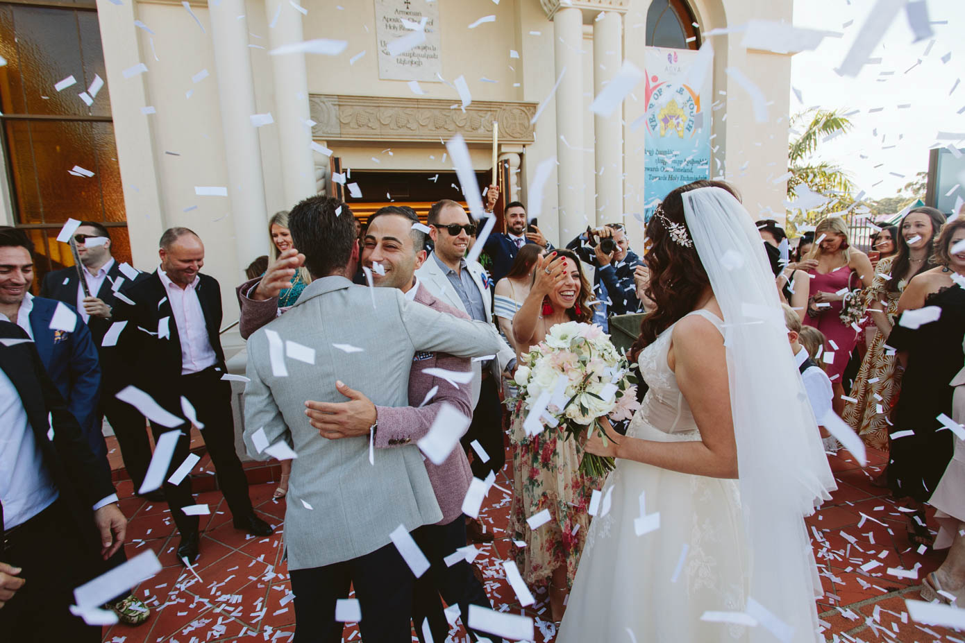 Guests shower the newlyweds with petals as they step outside, celebrating their first moments as husband and wife.