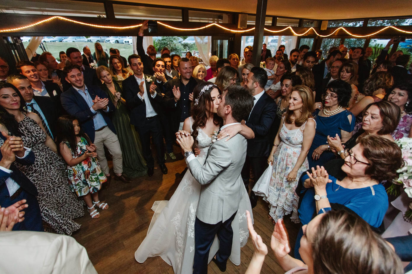 The couple shares their first dance, surrounded by loved ones at Dunes Palm Beach.